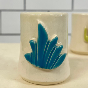 off-white ceramic shot glass depicting a three dimensional teal agave plant