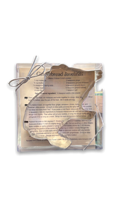 Metal cookie cutter in a clear plastic box with silver elastic ribbon