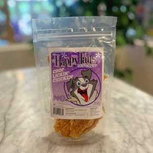 Clear plastic resealable food pouch showing contents of light brown dog treats with purple and white front label