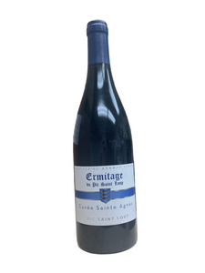 Glass wine bottle with white label with blue lettering