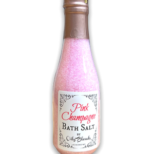 wine bottle shaped clear plastic bottle containing pink bath salts with a white front label