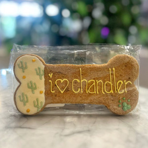 Light brown, bone shaped dog treat with icing Light brown, bone shaped dog treat with icing