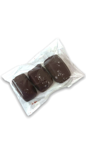 A clear packaging showing three dark chocolate covered caramels topped with coarse sea salt