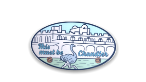 Oval sticker with image of Downtown Chandler buildings, ostrich and tumbleweeds in shades of light blues, pink and green.