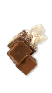Two wrapped milk chocolate truffles, with one more truffle split in half showing the thick chocolate amaretto center