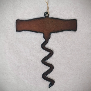 Cut out, rustic iron ornament in the shape of a corkscrew on a white background.