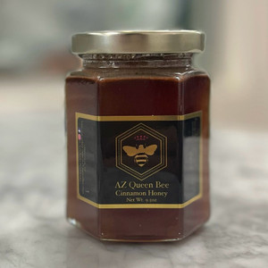 hexagonal glass jar with a gold lid. black label with gold border and a golden bee icon. cinnamon honey hexagonal glass jar with a gold lid. black label with gold border and a golden bee icon. cinnamon honey