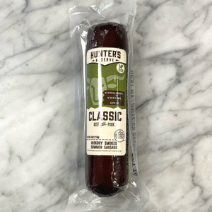 Smoked sausage in clear packaging with off-white and green label