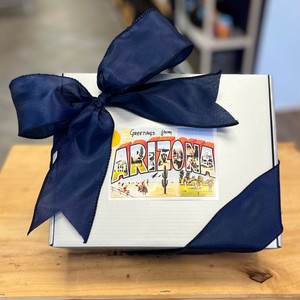 Silver gift box with blue ribbon tied in a bow and a Greetings from Arizona sticker