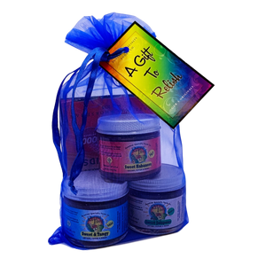 Three small glass jars with white lids, stacked in an organza gift bag.