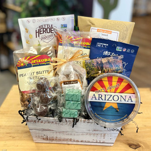 The contents of the Nothin' But Snacks inside of a faux white wood basket. The front of the baskets clearly displays the chocolate truffles and the nut tub that reads "Nuts about Arizona".