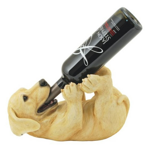 Yellow lab dog, lying on his back holding a bottle of wine