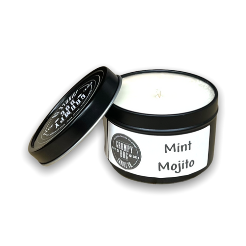 Candle in a round black tin with lid and white label with black lettering