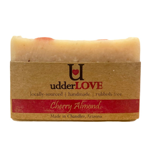 Light tan and pink bar of soap with tan paper wrapping for a label with dark pink writing