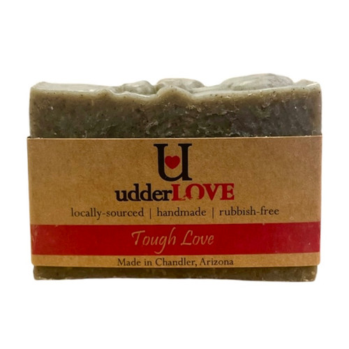 Dark gray bar of soap with tan paper wrapping with black and pink lettering