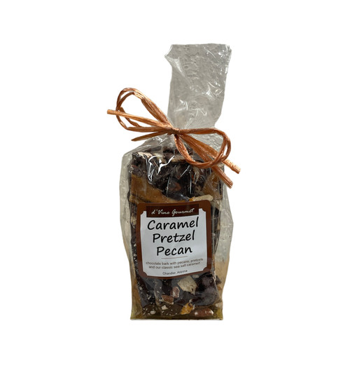 Clear cello food bag showing contents of dark chocolate bark with bits of caramel and pretzel tied with a brown bow