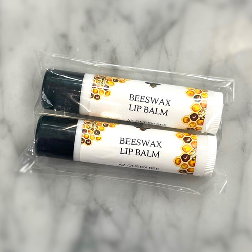 Two small tubes of lip balm with black lids. Both tubes reading "beeswax lip balm"