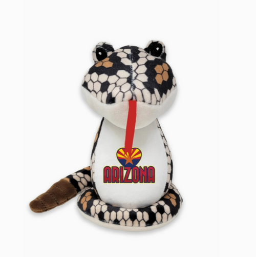 a plush version of a diamondback rattlesnake, with it's red tongue hanging out. on its white belly there is an Arizona flag in the shape of a heart and "Arizona" written in red font