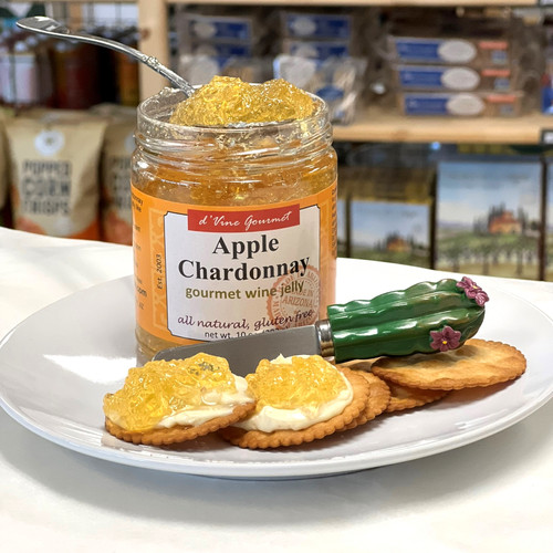 Open jelly jar with crackers and spreader on plate