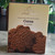 Cream and brown box containing brown chocolate cookies.