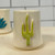 White ceramic shot glass with a three dimensional  green saguaro cactus