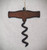 Cut out, rustic iron ornament in the shape of a corkscrew on a white background.