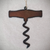Cut out, rustic iron ornament in the shape of a corkscrew on a white background.