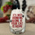 Clear stemless wine glass with the saying "It's Not Drinking Alone If The Cat is Home" in red lettering and small black paw prints.