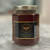 hexagonal glass jar with a gold lid. black label with gold border and a golden bee icon. cinnamon honey
