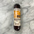 Sausage wrapped in clear packaging with orange and light tan front label displayed on a marble counter.