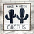 Square wood block with white background with black lettering and a black cactus with a star and another black cactus with a bowtie.