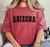 Person wearing red tee shirt with black block letters reading "Arizona"