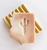 light pink bar of soap in the shape of Arizona with a cut of shape of a saguaro cactus in the middle - soap bar is laying on a wood block