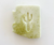 off white bar of soap with green flecks, in the shape of Arizona with a cut out in the middle in the shape of a saguaro cactus