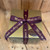 Closed glossy gold gift box with burgundy ribbon with "Made in Arizona" in gold lettering on the ribbon