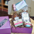 Gift contents displayed in a purple gift box with a "thank you" card on the top cover.  Full list of gift contents listed in product description.