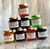Stack of eight jelly jars of assorted colors and flavors.