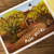 Open page of book with picture of trees and white lettering
