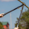 Hands reaching up to cut a branch with the Heavy Duty LeverAction Lopper