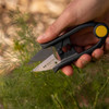 A hand snipping fennel fronds with the Regular Duty Herb Snips