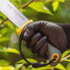 Close-up of a gloved hand gripping the Regular Duty Machete handle with its lanyard