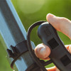 A hand pressing the rope lock button on the pruner handle