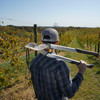 A person carrying the Pro Series Forged Lopper over one shoulder in a vineyard