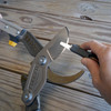 Close-up of the multitool carbide sharpener being drawn along the curved blade of a Pro Series forged steel pruner