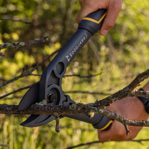 A hand cutting a lichen-covered branch with the Compact Duralight Lopper