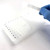 Peeling PCRSEAL-OA optically clear adhesive film from 96-well PCR plate with gloved hand