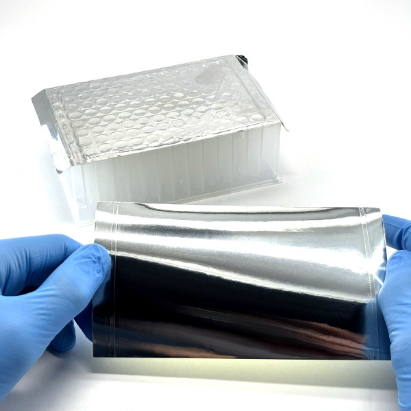 Holding PCRSEAL-ALM aluminum foil sealing film with gloved hands next to sealed deep-well plate