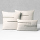 Micro Fringe Grigio square and lumbar pillows styled on a neutral indoor sofa