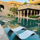 Six Curve polished concrete in-pool loungers partially submerged on a shallow tanning ledge at a luxury resort pool
