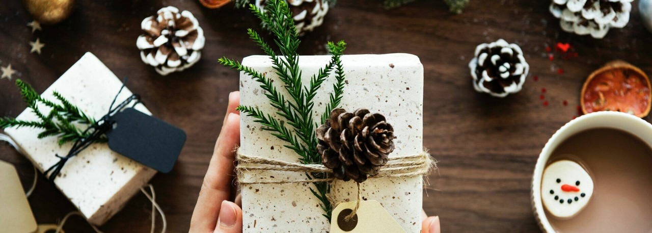 Cozy Wisconsin gift scene with coffee, greenery, and artisan items arranged on a wood table.